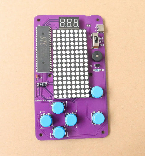 Noob Friendly Soldering Practice Kit For DIY Electronics Projects Learn To Solder With Detailed Circuit Schematics And Hands On STEM Education For Starters, showing purple circuit board with blue buttons and LED display.