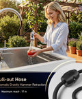 A woman using a retractable faucet attached to a stainless steel sink with an automatic pull-out hose; focus on kitchen flexibility.