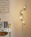 Industrial Gold Floor Lamp With 4 Black Leaf Shades in living room setting, modern tree style, lit reading light, includes 4 bulbs.