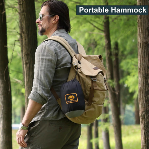 Man in forest with backpack carrying Camping Hammock With Mosquito Net Ready To Roll For Outdoors Ultralight And Easy Setup
