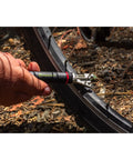 Compact Bar End Bicycle Tool Kit With Chain Tool Spoke Wrench in use on a bike wheel for quick roadside repair.