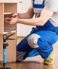 Leikius steel cabinet jack, blue telescoping pole with clamp, used as third-hand support for cabinet installation.
