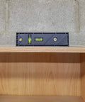 Straight Shooter Nine In One Measuring And Marking Tool Featuring Dual Levels showing depth gauge level on a wooden shelf.