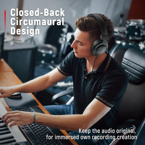 Man using studio monitor headphones for recording with 50mm drivers, focusing on music creation in a home studio.
