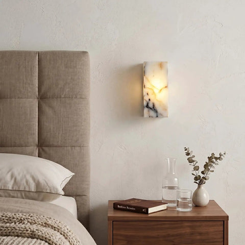 Marble Wall Sconce with Frosted Glass Globe and G4 LED (Rectangular) mounted above a bedside table in a cozy bedroom.