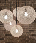 Hanging spherical rattan lamps against brick wall, similar to Arc Floor Lamp With Antique Bronze Base And Cream Rattan Shade