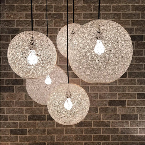 Hanging spherical rattan lamps against brick wall, similar to Arc Floor Lamp With Antique Bronze Base And Cream Rattan Shade