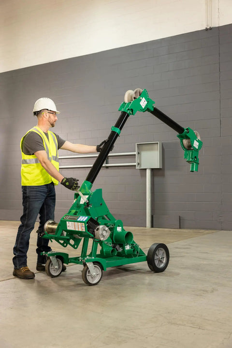 Greenlee 10k Tugger Package Featuring Dual Speed Motor For Faster Pulls, Real-Time Force Indicator Display And Heavy Duty Mobile VersiBoom Tow Rig Gear in use by an electrician