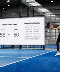 Woman playing paddle tennis with Pro Grade Wall Mounted Magnetic Whiteboard 72 By 48 Inches showing score and schedule in the background.