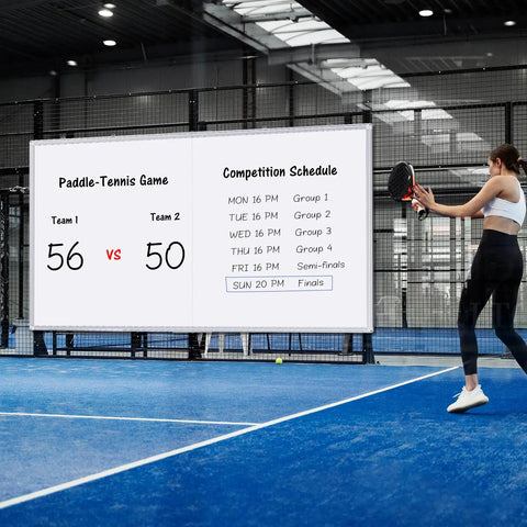 Woman playing paddle tennis with Pro Grade Wall Mounted Magnetic Whiteboard 72 By 48 Inches showing score and schedule in the background.