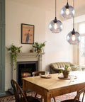 Globe Pendant Lights Set of 3 Hand Blown Glass With Clear Seeded Bubbles above dining table in modern rustic kitchen.