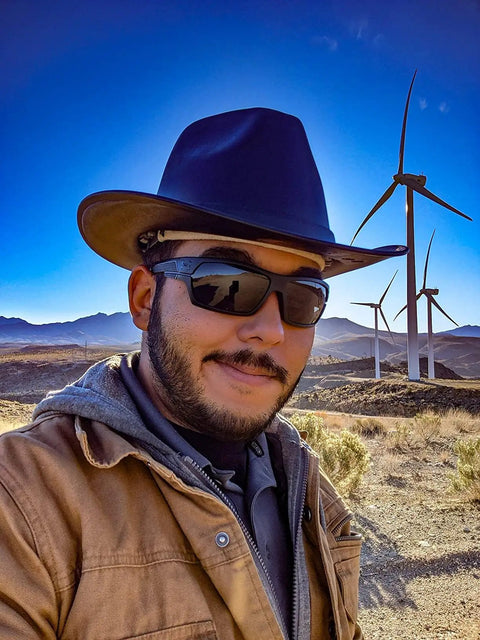 Person wearing Vulcan Cowboy Style Hard Hat With Six Point Deluxe Nylon Ratchet Suspension in a wind farm setting