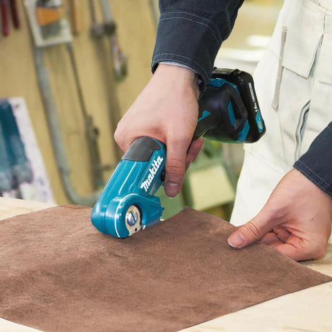 Person using Badass Compact 12V Max Lithium Ion Cordless Multi Cutter to trim flexible material on a work surface.