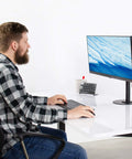 Man using computer at a desk with Heavy Duty Steel Reinforcement Bracket And Mount Plate For Glass Or Thin Desks.