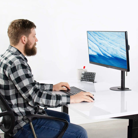 Man using computer at a desk with Heavy Duty Steel Reinforcement Bracket And Mount Plate For Glass Or Thin Desks.