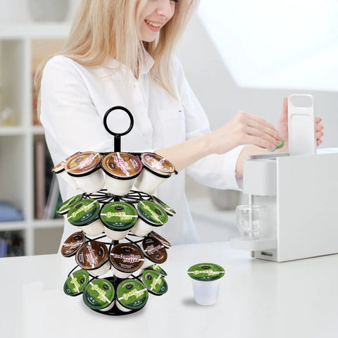 Person using a 36 Pod K Cup Carousel Coffee Holder Rotating Metal Pod Organizer In Black Detachable 360 Degree Stand For Home And Office Counters Keeps Your Coffee Pods Within Reach on the kitchen counter