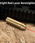Bore Sight Laser For 243 And 308 Caliber Rifles, Red Dot Sighting Tool in brass, emitting red laser on sand surface