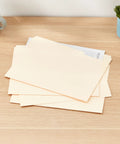 Heavy Duty Manila File Folders With Reinforced Tabs For Zero Hassle Workspace Organization And Doc Storage Built Tough Letter Size Sheets on desk with coffee.