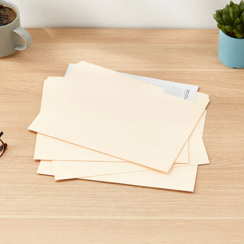 Heavy Duty Manila File Folders With Reinforced Tabs For Zero Hassle Workspace Organization And Doc Storage Built Tough Letter Size Sheets on desk with coffee.