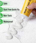 Hand applying spackle from Drywall Repair Kit With Two Tubes Of Spackle 120G Each, Two Scrapers And Two Sanding Pads for wall repair