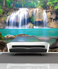 Epic Deep Forest Waterfall Wall Mural Peel And Stick Self Adhesive Wallpaper Large 141.7 By 98.4 Inches Six Panel Set For Living Room And Dining Room Decor Nature Landscape Poster featuring a serene waterfall over rocks in a lush forest, viewed from a modern living room with a black and white sofa.