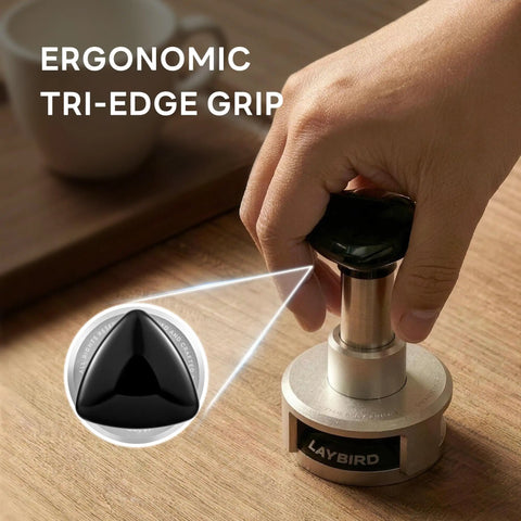Person holding Pro Grade 58.5mm Espresso Tamper With 25Lb Constant Pressure Spring Loaded System on wooden counter, ergonomic grip