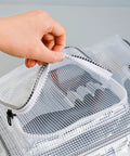 Hand opening the zipper of a Clear Pvc Crossbody Shoulder Bag For Tool Storage And Work Equipment Cleanroom Organizer Purse.