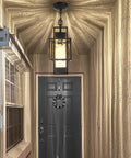 Top Tier 15 Inch Outdoor Indoor Pendant Light Featuring Heavy Duty Black Metal And Thick Water Seeded Glass illuminating an entryway.