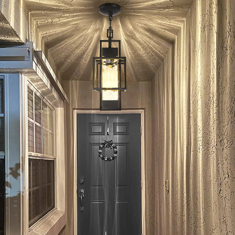 Top Tier 15 Inch Outdoor Indoor Pendant Light Featuring Heavy Duty Black Metal And Thick Water Seeded Glass illuminating an entryway.