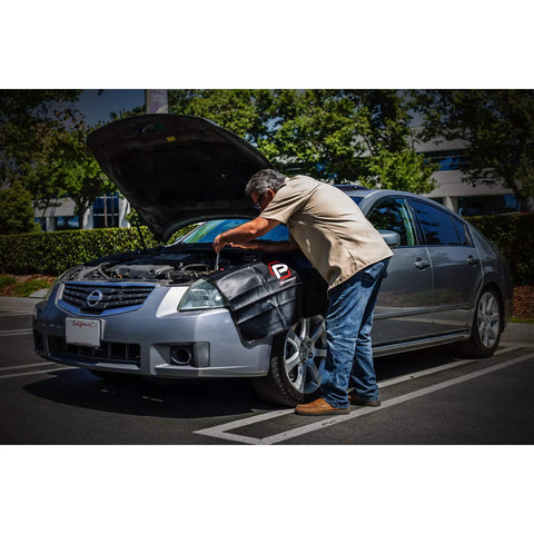 Mechanic using Heavy-Duty 24 By 34 Inch Black Plush Vinyl Fender Cover Pad for Auto Repair And Maintenance on silver car.