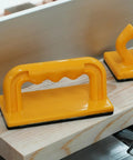 Heavy Duty Push Block And Push Stick Set For Table Saws Router Tables Band Saws on a work surface, featuring yellow safety grips.