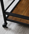 Close-up of the Prime Rolling Industrial Bar Cart With Heavy Duty Dual Tier Shelves showing a rustic wood shelf and metal frame on casters.