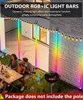 Backyard party with string lights on poles, colorful light bars, and a group of people enjoying an evening gathering