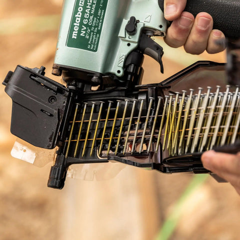 Close-up of Two And A Half Inch Coil Siding Nailer Pro Bundle with exposed nail coil ready for installation.