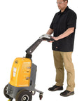 Person operating Heavy Duty Electric Powered Tugger With 1000 Lb Pull Capacity For Effortless Factory Material Handling in bright yellow.