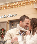 Couple close together with mugs, under string lights, text 'Let it Glow', promoting 7 Watt Night Light Replacement Bulbs 12 Pack.