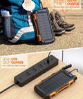 42800mAh Solar Charger Power Bank Portable Charger With USB C Input Output Dual USB Ports QC 3.0 Fast Charge External Battery Pack Built-In Super Bright Flashlight Charges Three Devices Outdoor Orange on a backpack