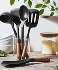 Silicone Wood Handle 5-Piece Cooking Utensil Set with BPA-Free Matte Black Silicone displayed on a kitchen counter