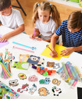 Children using 24 Pack Cute Stationery Set For Classroom Rewards And Gift Bags Includes Mini Notebooks Pencils Rulers Erasers Sticky Notes Stickers And Cute Goodie Bags For Birthday Gifts Class Activities School Office Supplies on desk.