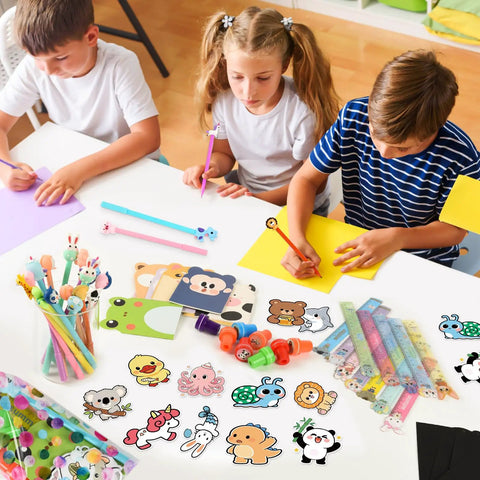 Children using 24 Pack Cute Stationery Set For Classroom Rewards And Gift Bags Includes Mini Notebooks Pencils Rulers Erasers Sticky Notes Stickers And Cute Goodie Bags For Birthday Gifts Class Activities School Office Supplies on desk.