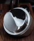 Close-up of Walnut 58.35mm Espresso Distribution Tool, Adjustable Depth, Stainless Steel Leveler for 58mm Portafilters on a wooden surface.