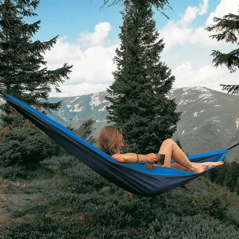 Person relaxing in Double Travel Hammock Ultralight Parachute Nylon With Breathable Fabric Packable Carry Bag Two Tree Straps And Aluminum Carabiners