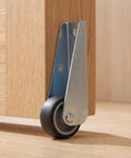 Close-up of 5pcs Wooden Gate Wheel Side Mount Caster with 1.5 Inch Rubber Rollers attached to wooden furniture.