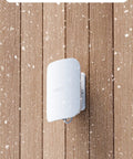 Outdoor 7 Dual Band Mesh WiFi Router With IP66 Weatherproof mounted on wall covered in snowflakes.