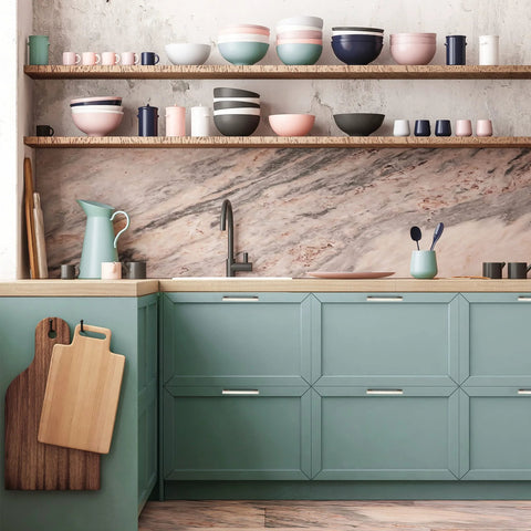 Modern kitchen with pastel dishes on open shelves and 5 inch brushed nickel cabinet pulls on green cabinets.