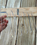 Top Shelf 6 In 1 Board Handle Router Template For Woodworking Pros Premium Clear Acrylic held in hand against wood background.