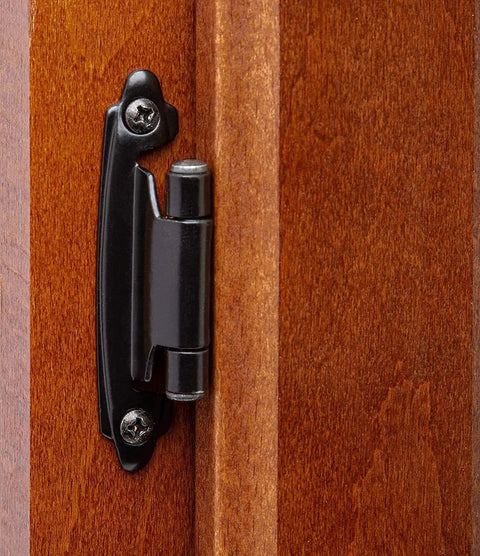 Half Inch Overlay Matte Black Cabinet Hinges Self Closing mounted on a wooden cabinet door in kitchen or bath.