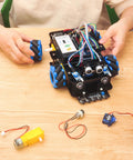 Toy robot car kit with blue mecanum wheels and exposed wiring for Arduino Mega2560 – front view