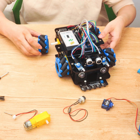 Toy robot car kit with blue mecanum wheels and exposed wiring for Arduino Mega2560 – front view