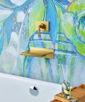 High Flow Wall Mount Tub Filler With Single Lever Large Waterfall Spout CUPC Certified Pressure Balance Rough In Valve Included Brushed Gold Finish Modern Bath Upgrade For Spa Vibes And A Handy Shelf For iPad Candles Or Glassware in bathroom setting